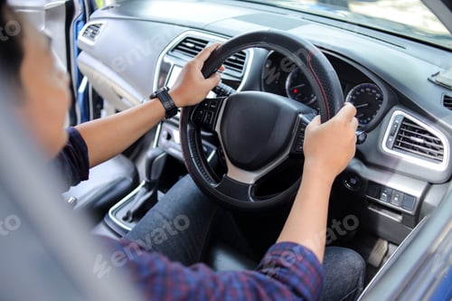Preview: Closeup Behind Shoulder Shot of Male Driver Holding Black Leather Steering Wheel While Driving Car