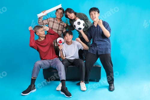 Preview: Group of Excited Male Indonesian Football Fans Cheering Together on Couch