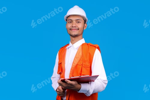 Preview: Young Asian Construction Engineer in Hard Hat and Orange Vest Holding Clipboard