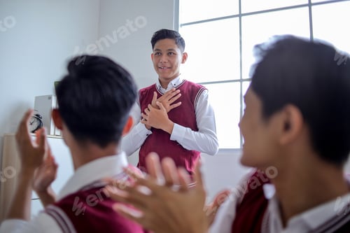 Preview: High School Student Standing Proudly in Class While Classmates Applaud Him