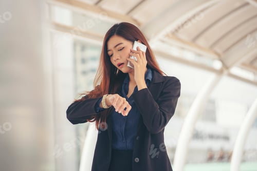 Preview: Time out concept.Urgent work,business woman seeing wrist watch and using mobile phone before meeting