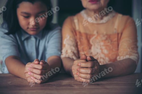 Preview: Prayer concept. Asian senior woman and Thai child praying, hope for peace the world and free from co