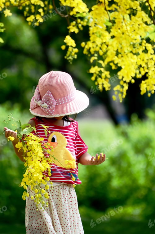 Preview: Little girl playing under tree (yellow flower),Thailand.