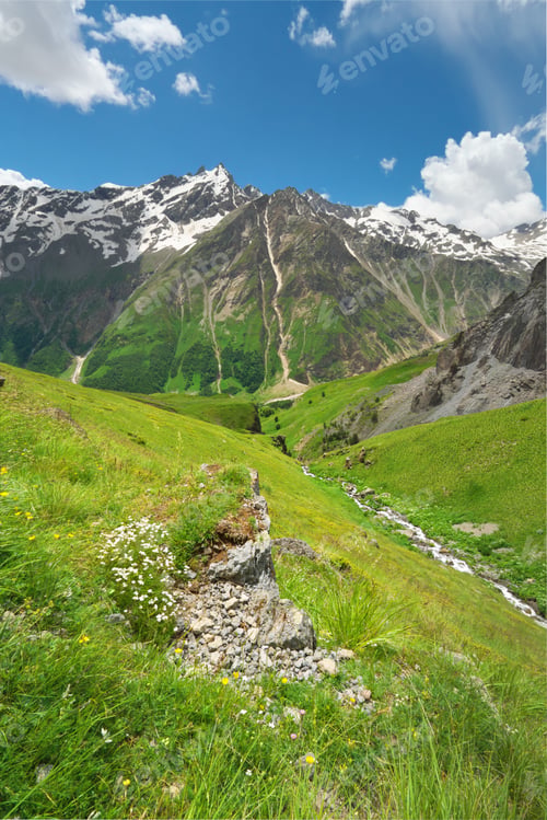 Preview: Beautiful Mountain Landscape Vertical View With Green Valley And Small River Flowing Under Blue Sky