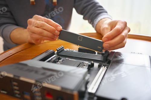 Preview: Man installing DDR5 RAM module into a computer motherboard