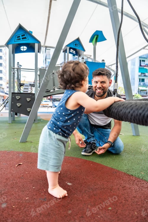 Preview: Father and son playing together at urban playground