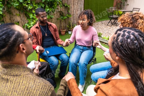Preview: Diverse people holding hands during outdoor group therapy session