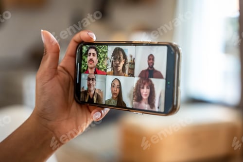 Preview: Hand holding smartphone displaying diverse group video call