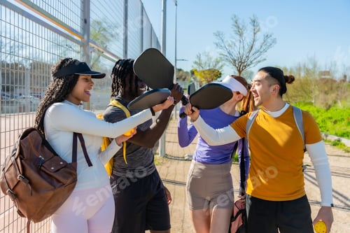 Preview: Diverse friends cheering playing pickleball on outdoor court
