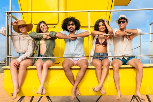 Preview: Diverse friends enjoying summer vacation relaxing on lifeguard tower