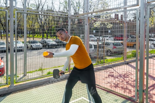 Preview: Young man playing pickleball on outdoor court