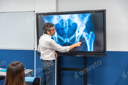 Preview: Doctor teaching anatomy pointing at hip x ray on screen