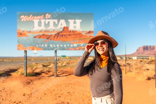 Preview: Woman enjoying utah welcome sign at monument valley road trip