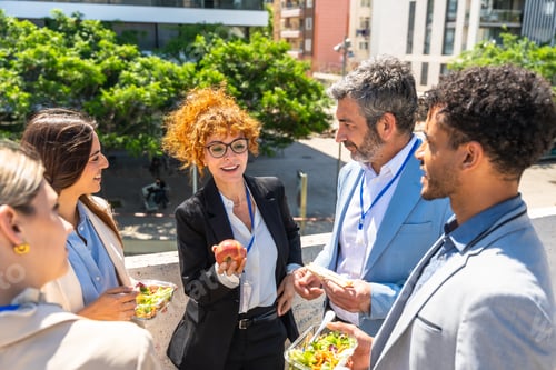 Preview: Business colleagues having lunch break outdoors talking and networking