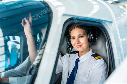Preview: Female pilot smiling wearing headset inside cockpit