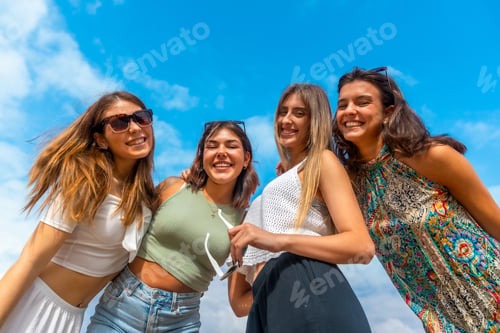 Preview: Group of young women smiling under blue sky