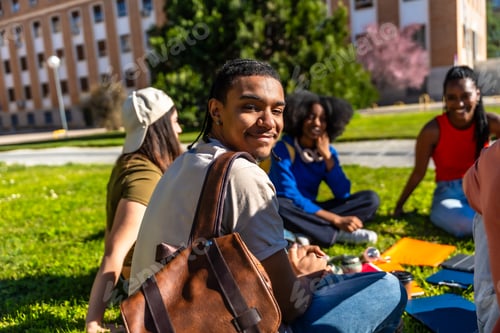 Preview: Diverse university students smiling, studying, and socializing on campus lawn