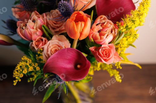 Preview: Bright flowers in a vase placed on a wooden table creating a colorful display in a bright room with