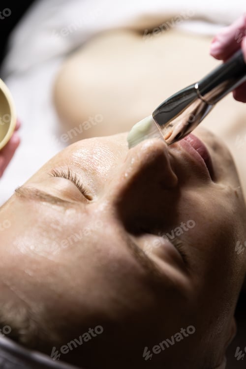 Preview: Cosmetic application with a brush. Facial treatment for a European woman.