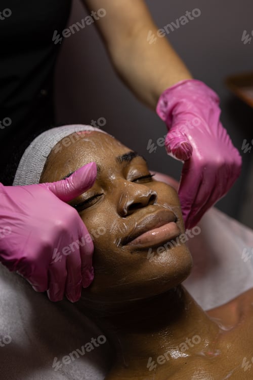 Preview: African woman in beauty clinic doing a facial evaluation and a cosmetology treatment.