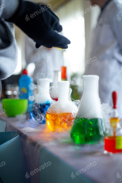 Preview: Chemistry fun experiment in a classroom with colorful liquids and smoke being observed by students w