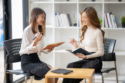 Preview: Two Women Engaged in Discussion at Modern Workplace Setting