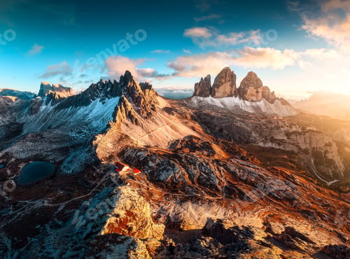 Preview: Alpine landscape of sunset over Tre Cime mountain peak and mountain hut during autumn in Dolomites,