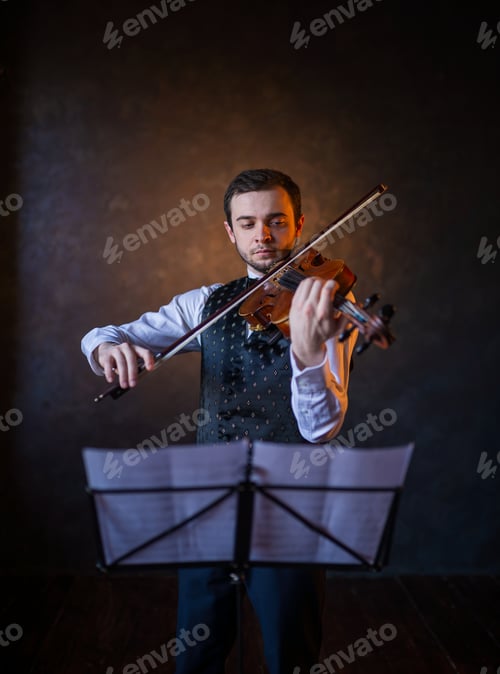 Preview: Elegant male violinist playing instrument behind music stand