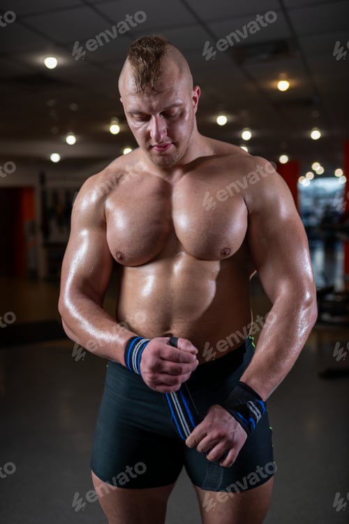 Preview: Muscular man wrapping his wrists before a heavy lift