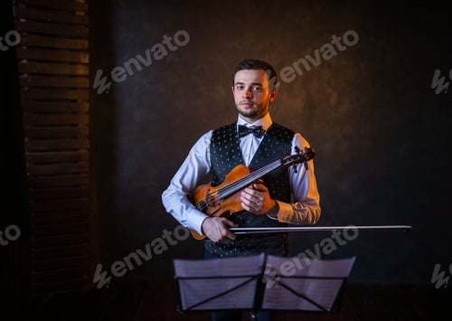 Preview: Violinist standing with instrument and bow behind music stand