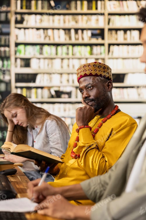 Preview: Thoughtful adult learner holding open book at library study table