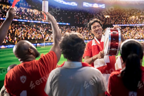 Preview: Enthusiastic man on soccer stadium beating drum, encouraging players