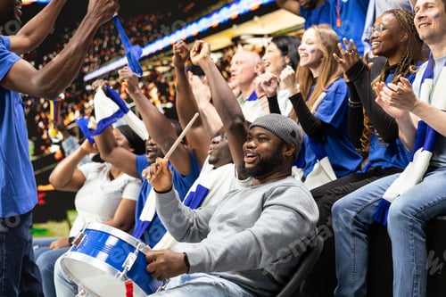 Preview: Black football supporter with drum leading blue stadium crowd chants