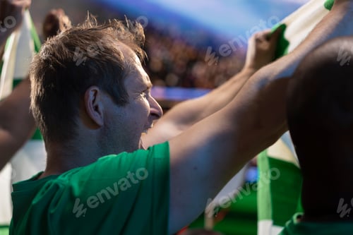 Preview: Close up of football fan smiling in stadium crowd, enjoying team performance