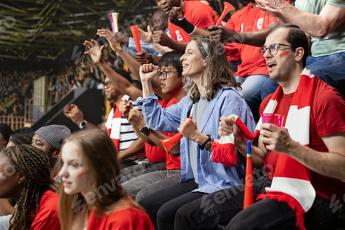 Preview: Packed stadium crowd of red team football supporters cheering with red horns