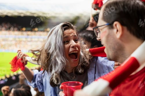 Preview: Excited woman football fan jumping and cheering after game winner