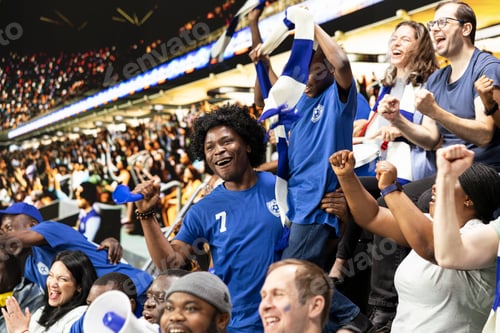 Preview: Young child fan celebrates with cheering blue soccer supporters in stadium