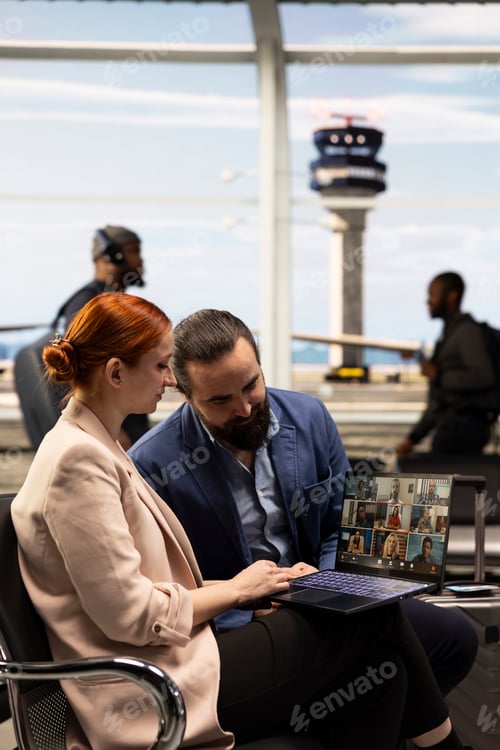 Preview: Corporate team using laptop for web conference before flight in airport