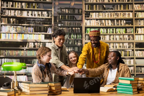 Preview: Students and adult learner uniting hands over library table after study session