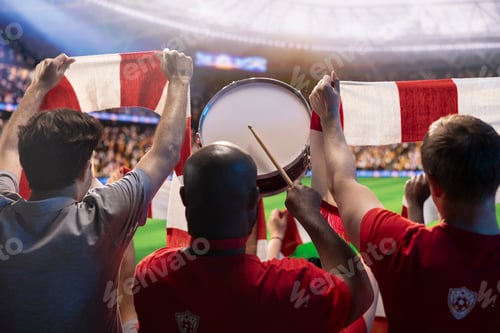 Preview: Soccer fans in stadium tribunes playing drum during intense soccer match