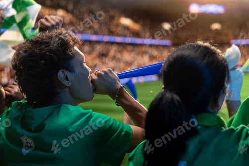 Preview: Close up of football fans with favorite team jerseys blowing vuvuzela