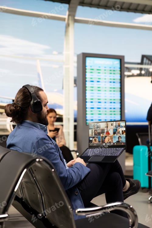 Preview: Professional businessman attending video conference on laptop in airport lounge