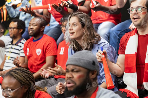 Preview: Red team football fans reacting with tension and anticipation in packed stands