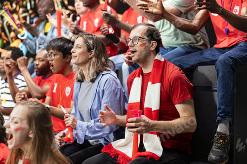 Preview: Red team football supporters cheering in crowded stadium stands