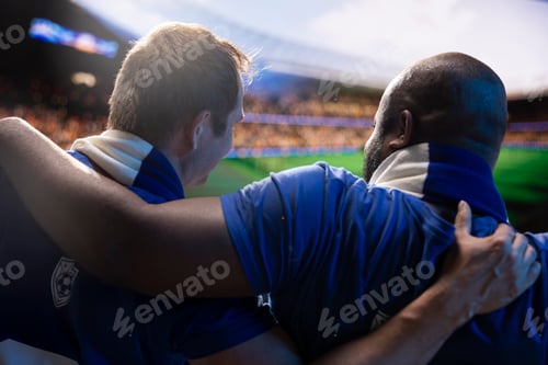 Preview: Close up of soccer supporters embracing each other in packed stadium
