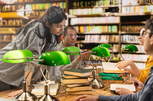 Preview: Young woman leans over open books during library group discussion