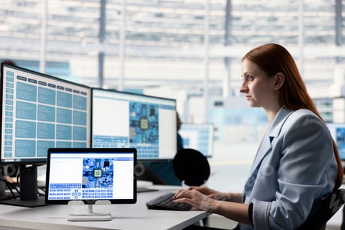 Preview: Female systems architect in tech laboratory configures PCB electronic hardware