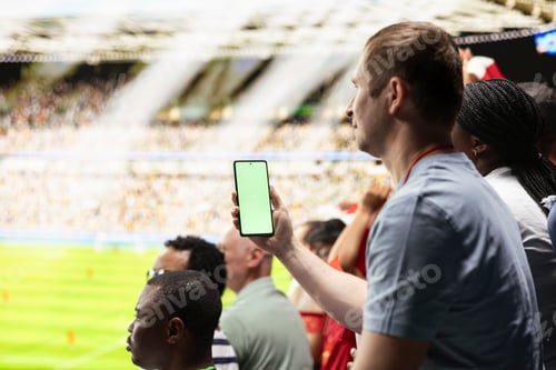 Preview: Vertical green screen smartphone held by soccer supporter during live game