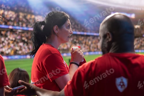 Preview: Focused soccer supporters watching dramatic match in stadium