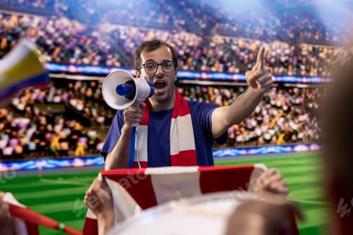 Preview: Football supporters chanting with megaphone in packed stadium